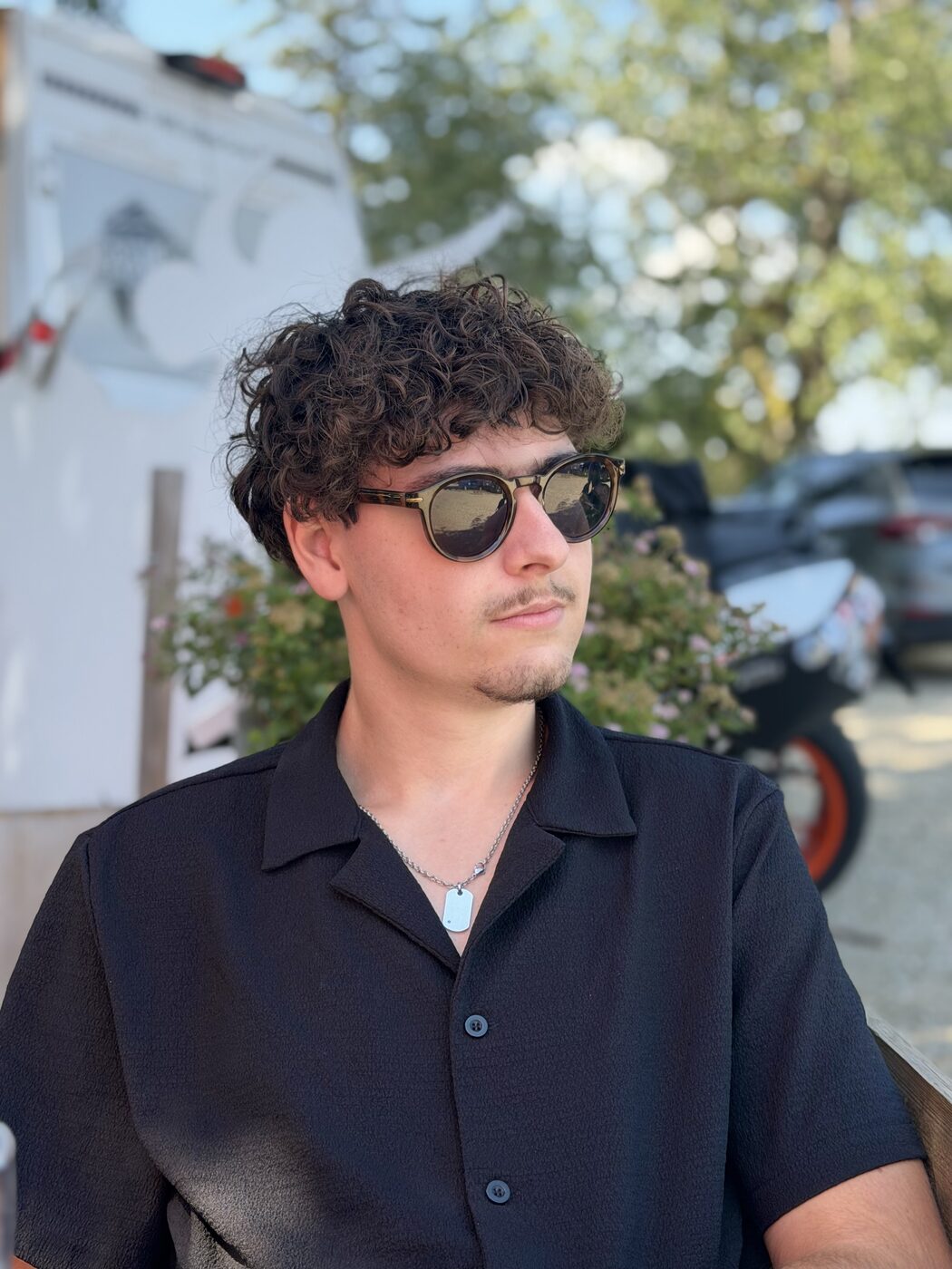 Romain en chemise noire et lunettes de soleil